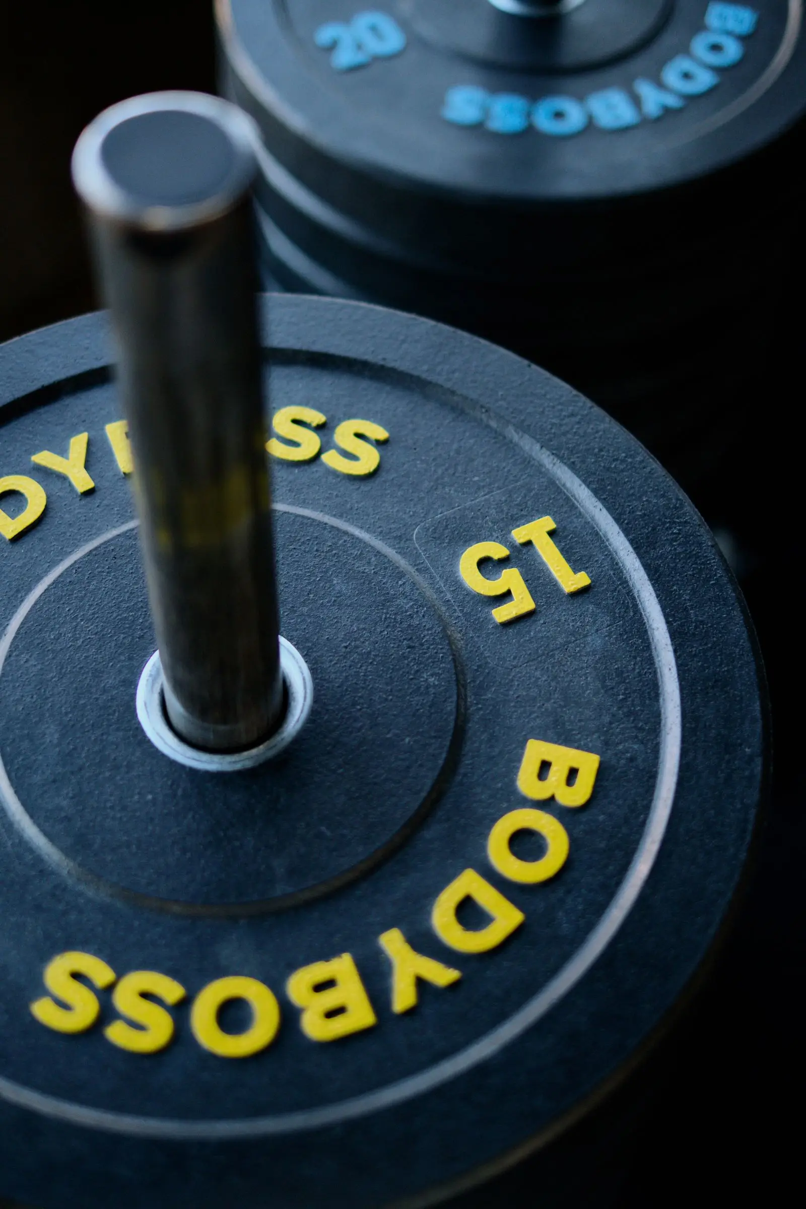 A barbell with a single plate loaded on the sleeve