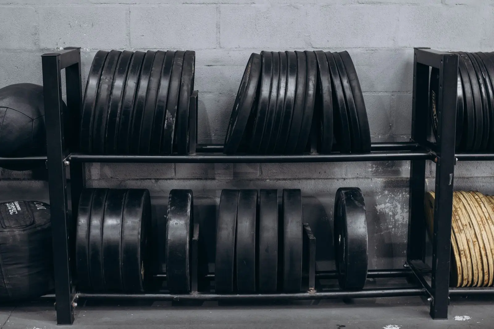 Weight plates racked in order on the storage frame