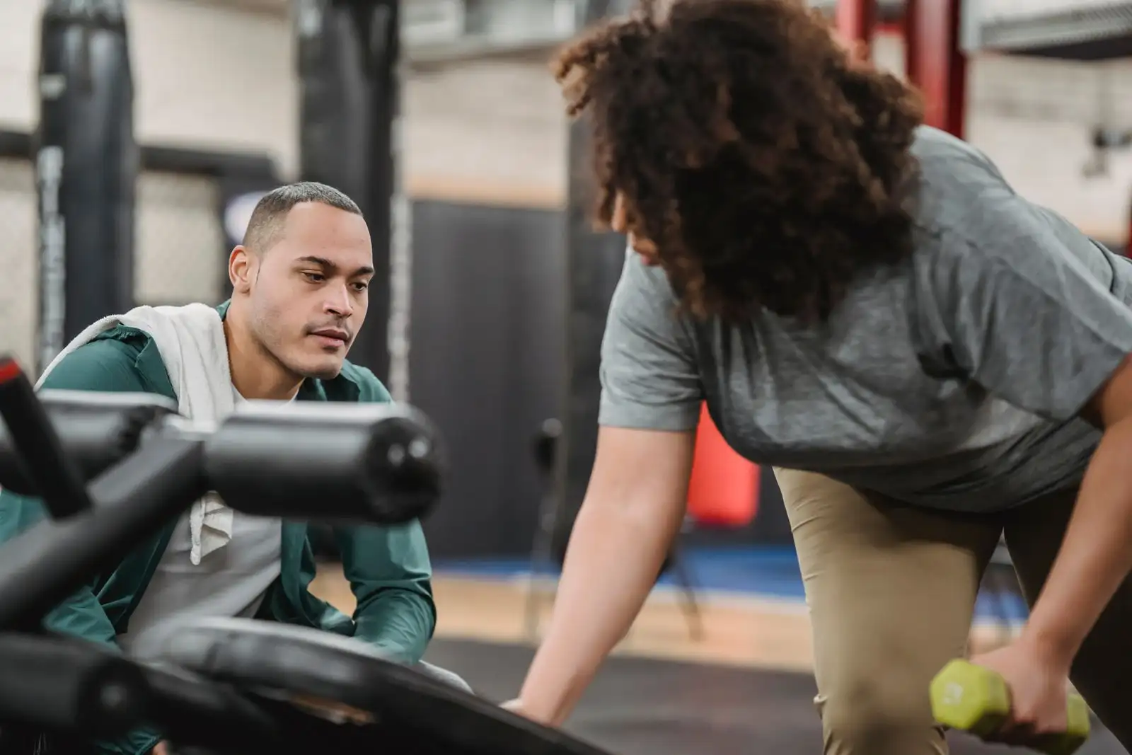 A coach standing alongside a lifter, watching a set